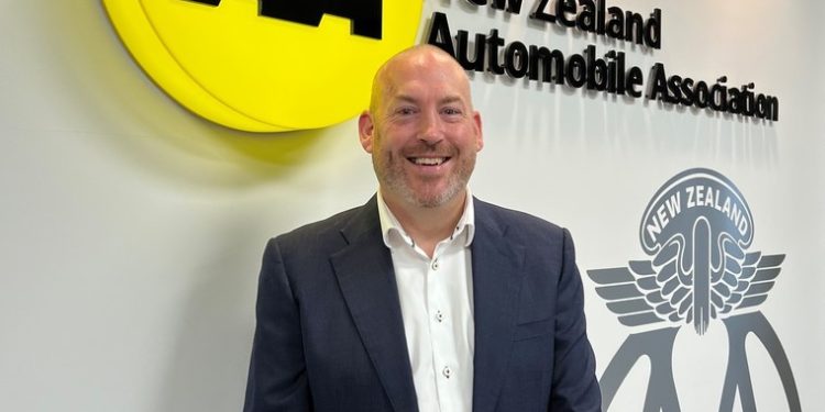 Johnathan Sergel standing in front of AA New Zealand sign