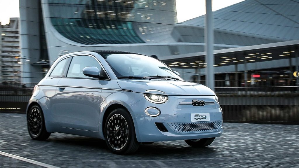 Fiat 500e driving along road in city