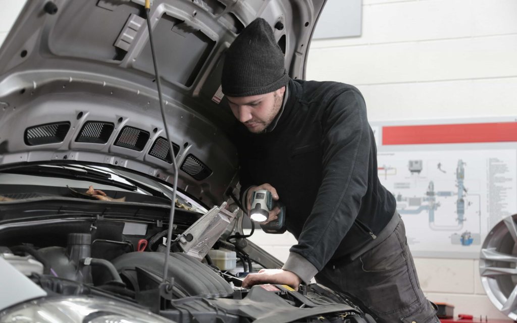 Mechanic inspecting car engine