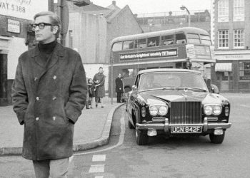 Sir Michael Caine standing next to Rolls-Royce first car