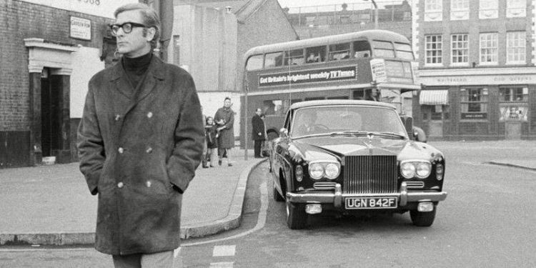 Sir Michael Caine standing next to Rolls-Royce first car