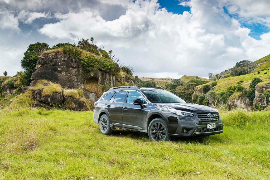 Subaru Outback XT parked in front of roack formations
