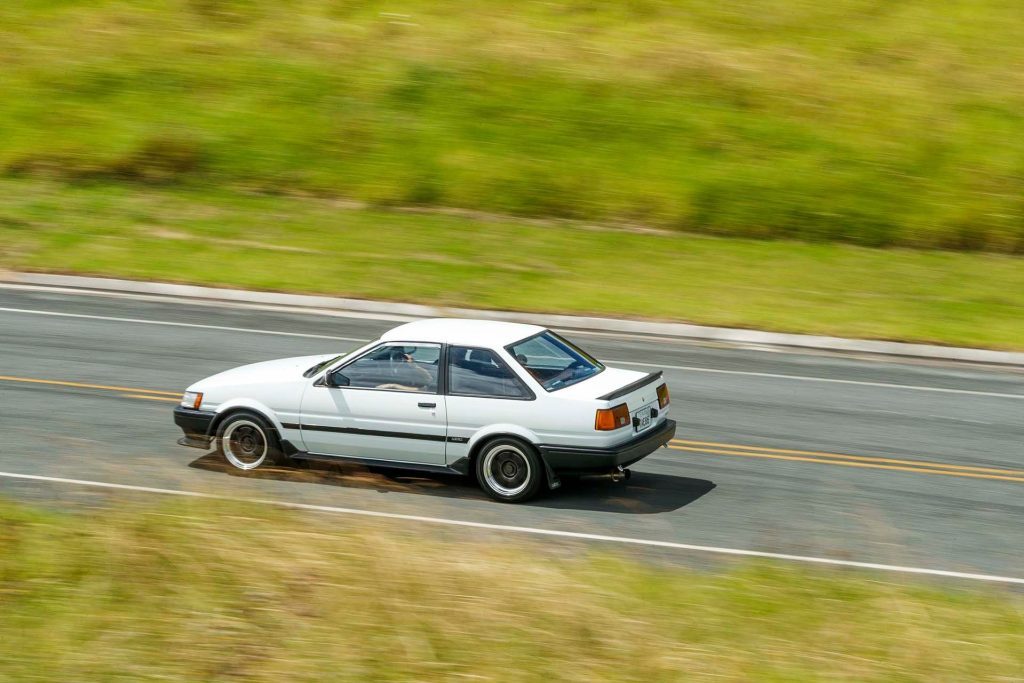 Toyota Corolla Levin GT driving past grassy hills