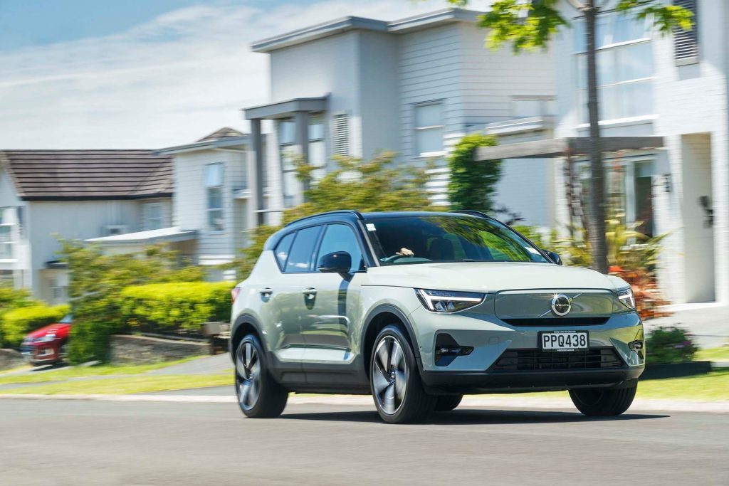 Volvo XC40 Recharge P8 driving past houses