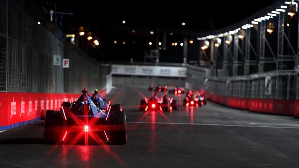 Formula E cars racing a night