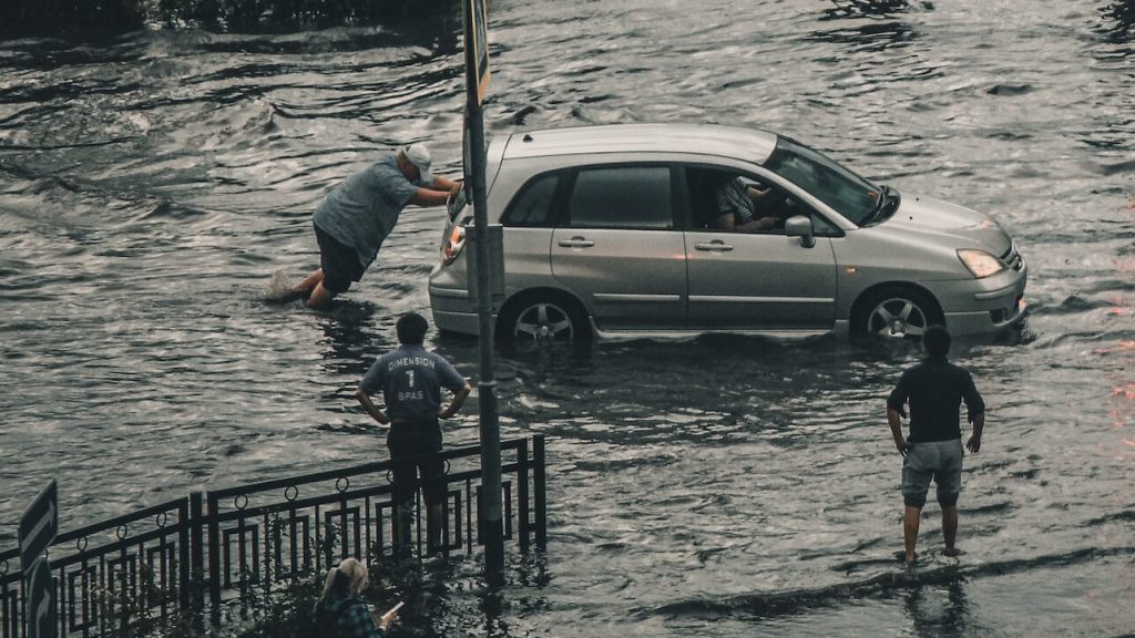 Man pushing car in flood