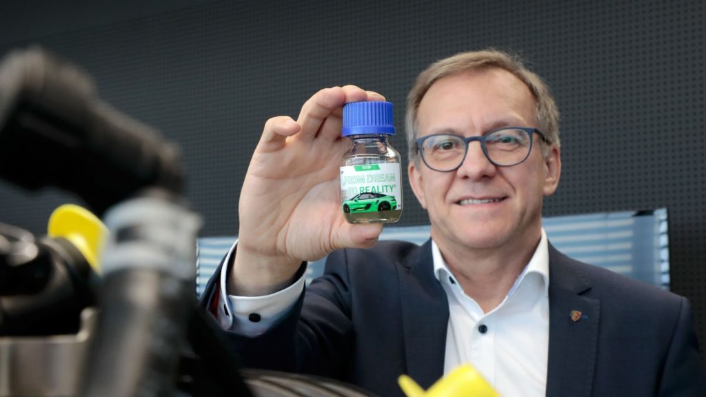 Karl Dums of Porsche holding synthetic fuel eFuel sample