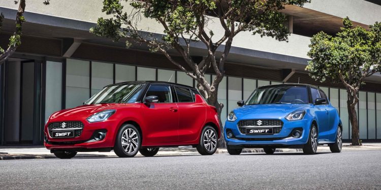 Two Suzuki Swifts parked next to trees