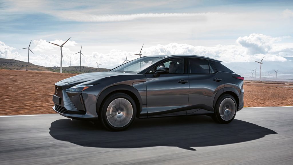 Lexus RZ 450e driving past wind farm side view