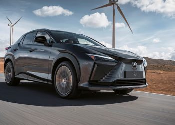 Lexus RZ 450e driving past wind farm front three quarter view