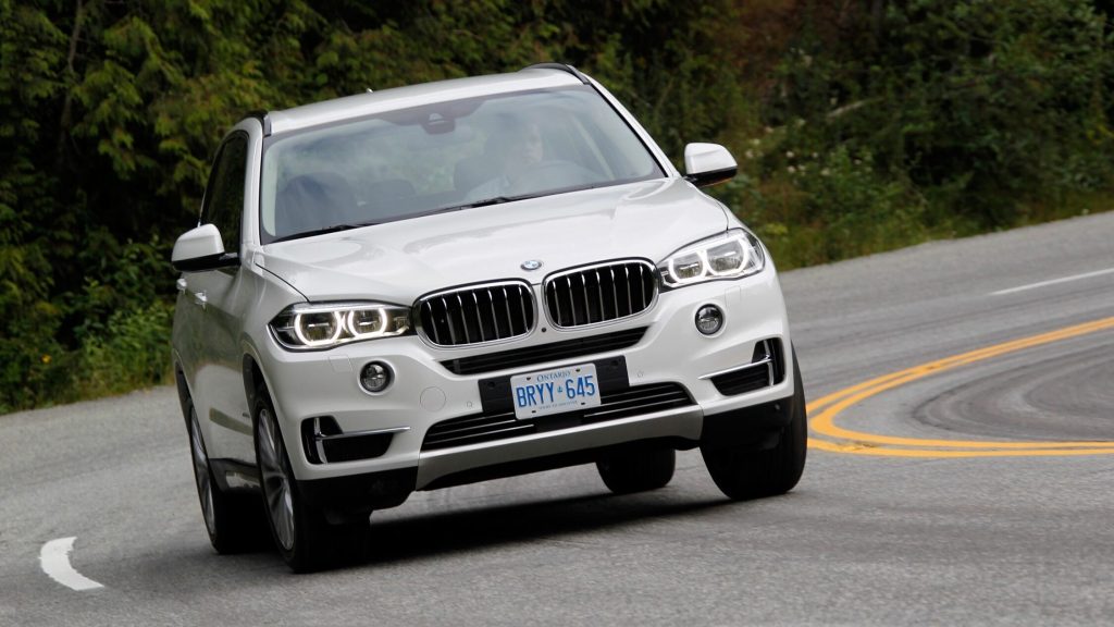 BMW X5 driving around corner front view