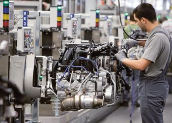 Man building Porsche engine in factory