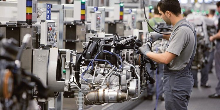 Man building Porsche engine in factory