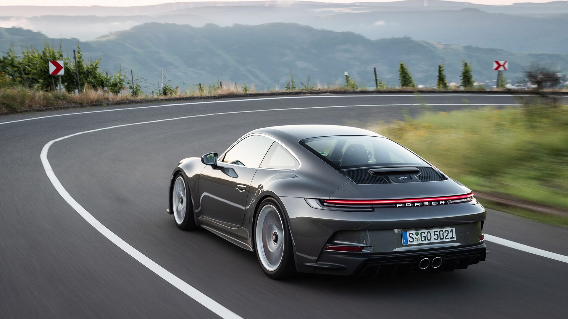 Porsche 911 (992) GT3 Touring driving around corner