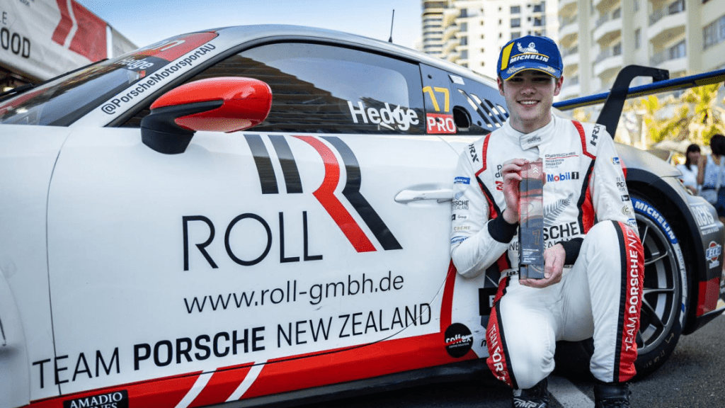 Callum Hedge holding trophy next to Porsche Carrera Cup car