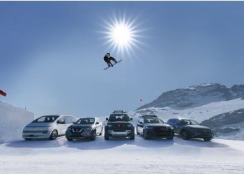 Snowboarder jumping row of cars
