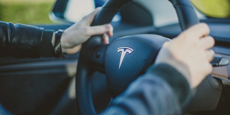 Person holding Tesla steering wheel