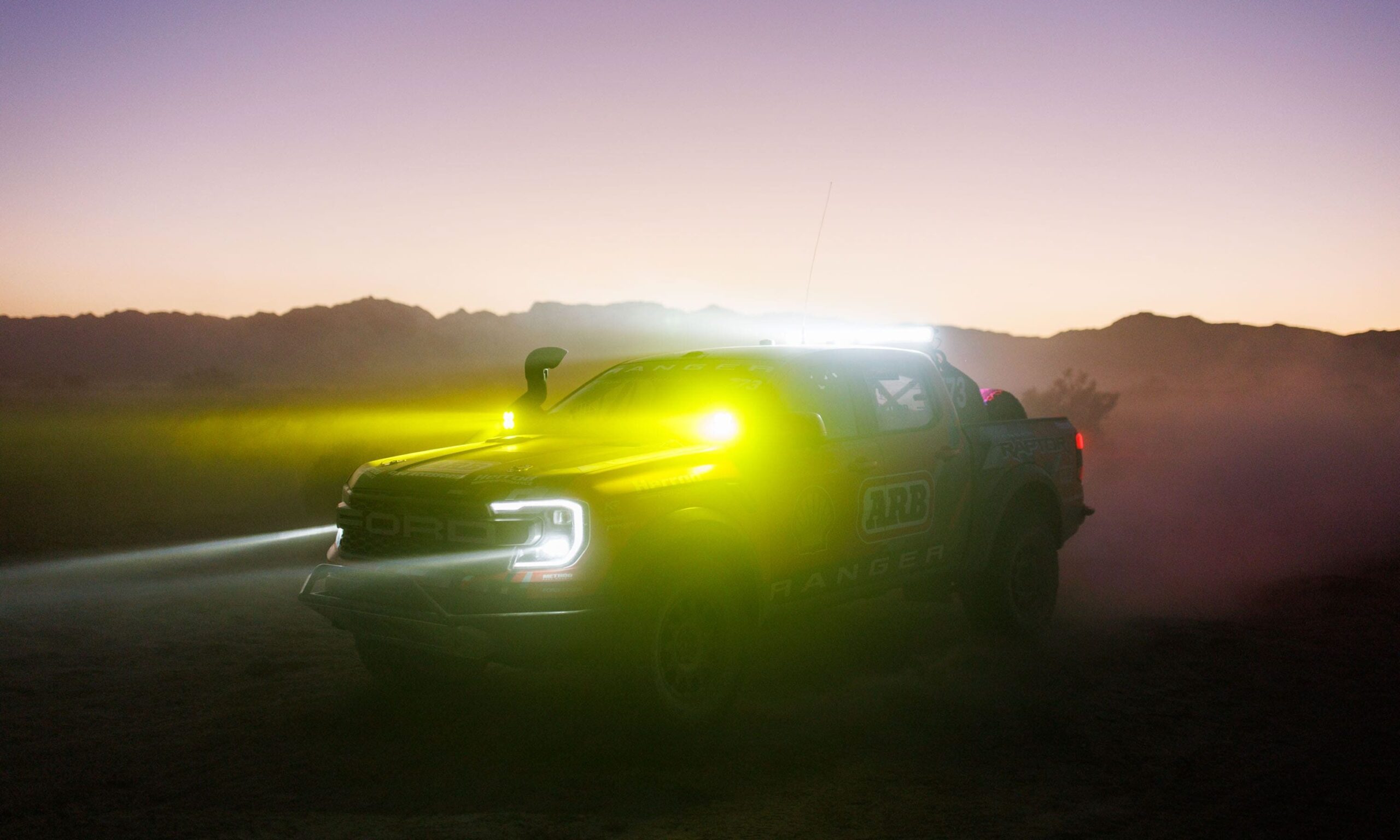 Ford Ranger Raptor Baja racer at night in dust