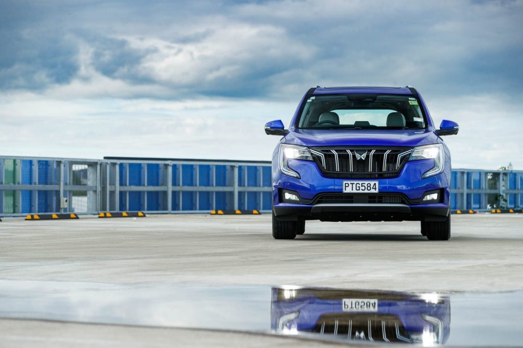 Front of Mahindra XUV700 SUV, with a puddle in front