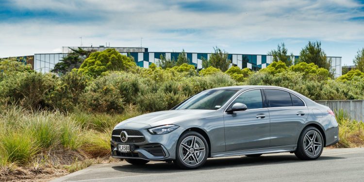 Silver Mercedes C 350e PHEV parked next to a garden