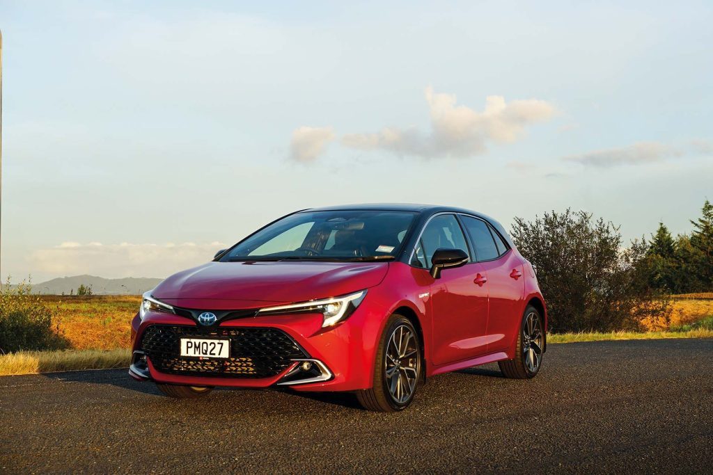 A red Toyota Corolla ZR Hybrid parked in the sun