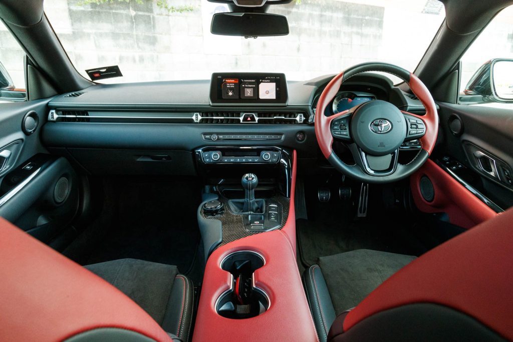 Front cockpit view of the 2022 GR Supra, showing off its red leather, and carbon fibre.