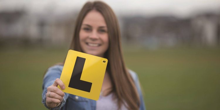 Woman holding learner license plate
