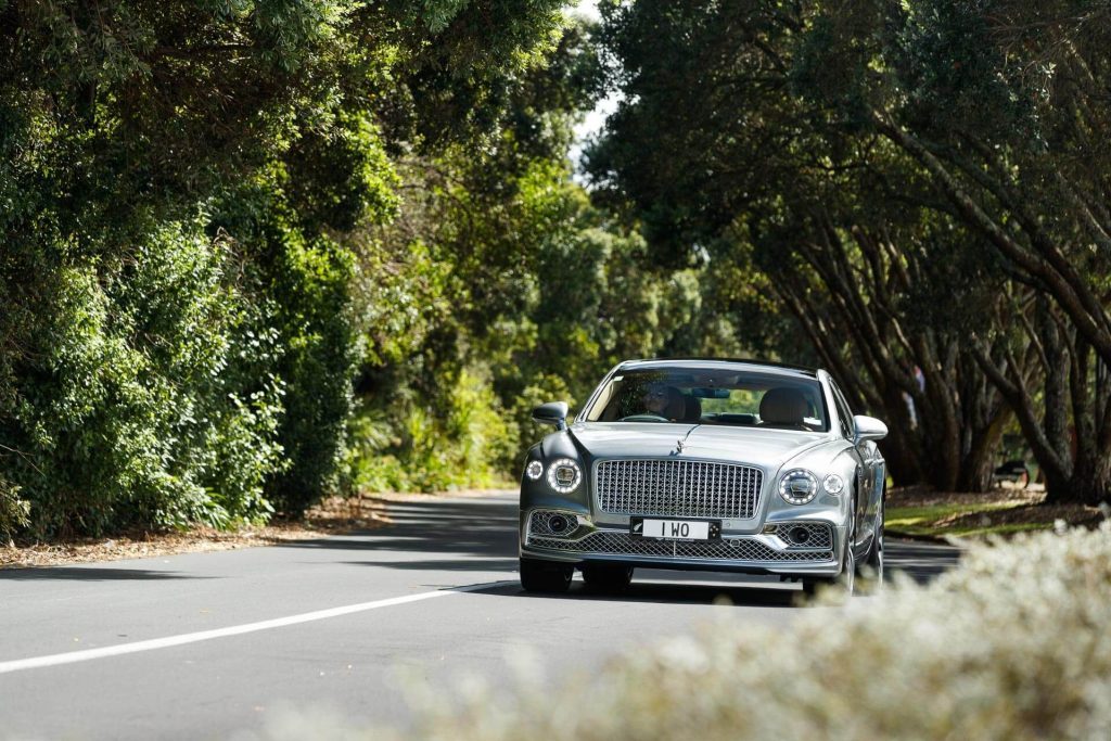 The Bentley Flying Spur Hybrid driving along a shaded road
