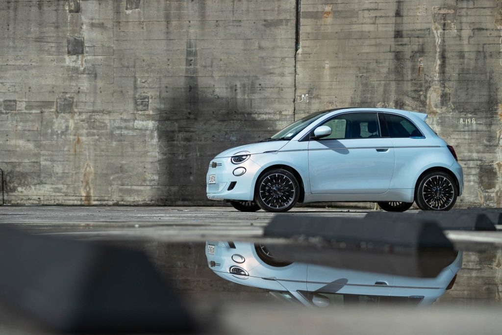 Fiat 500e parked with reflection in puddle