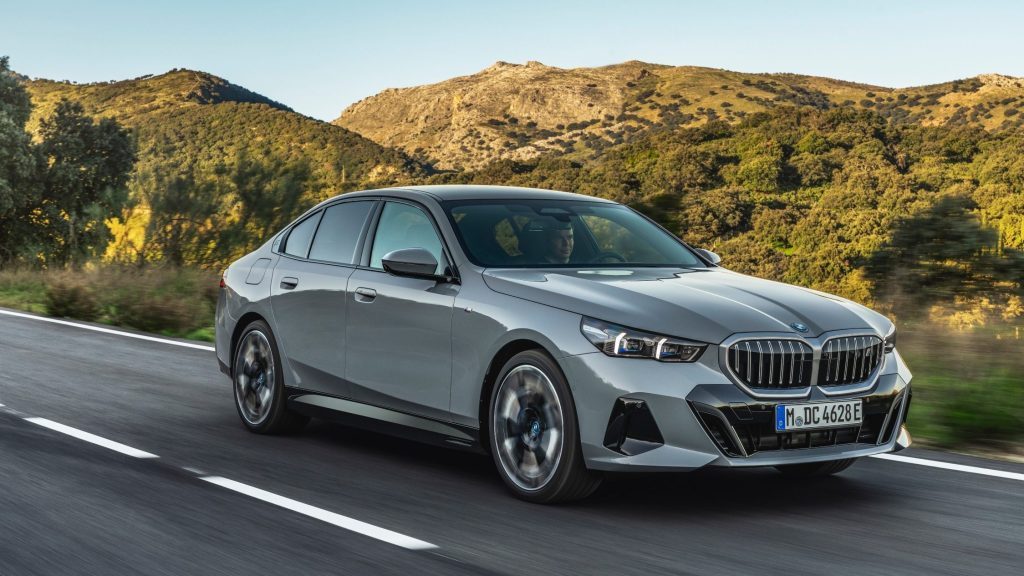 BMW 5 Series driving past mountains