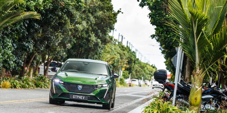 The new Peugeot 308 GT PHEV driving in suburbia