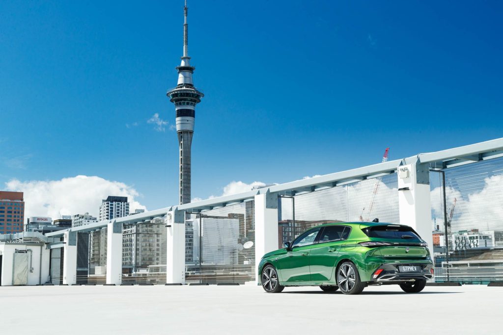 Rear view of green Peugeot 308 GT PHEV with Auckland Skytower visible