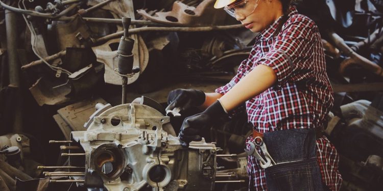 Woman mechanic working on engine