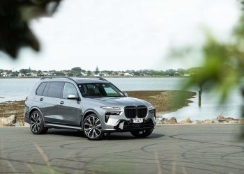 BMW X7 xDrive40D front quarter shot behind leaves