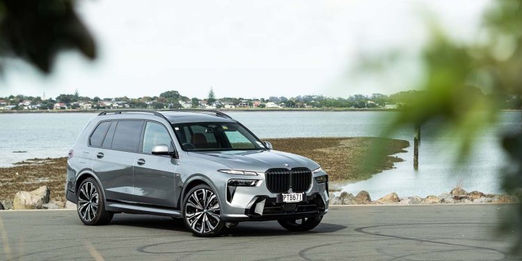 BMW X7 xDrive40D front quarter shot behind leaves