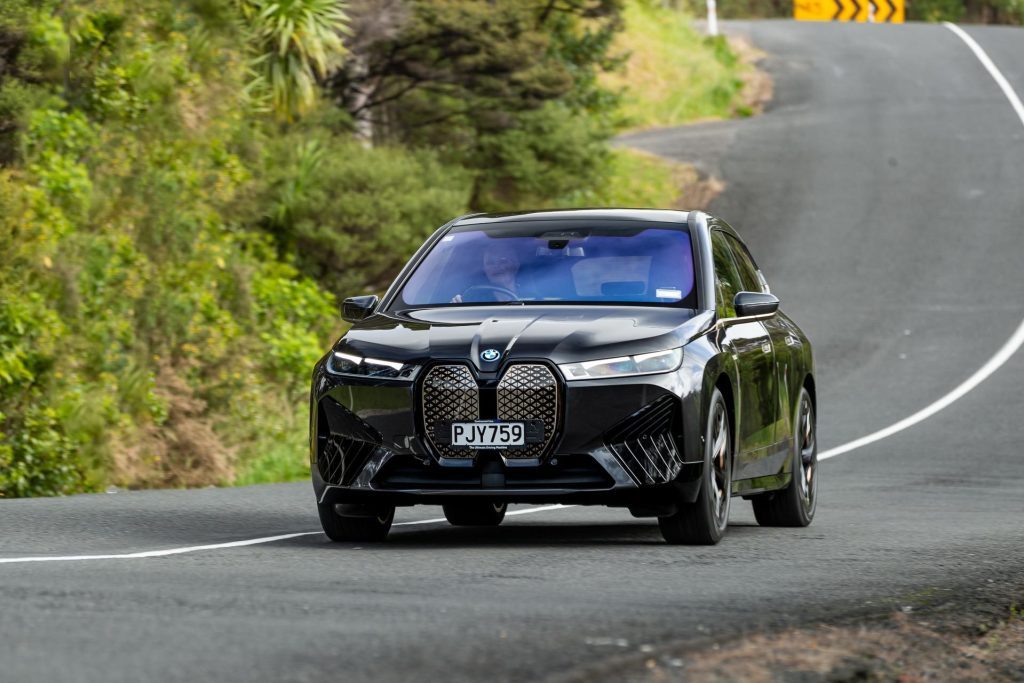 Action shot of the BMW iX M60 driving down a backroad