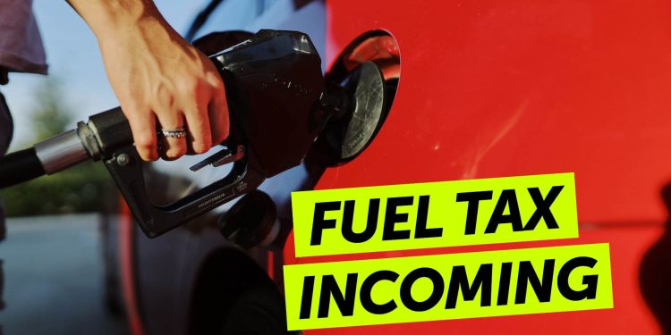 Person with hand on fuel nozzle while filling car