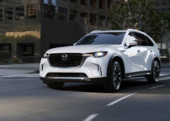 Mazda CX-90 driving around corner in city