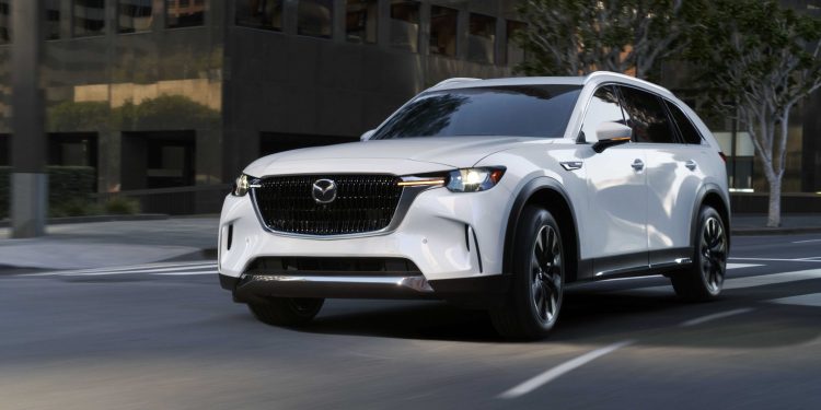 Mazda CX-90 driving around corner in city