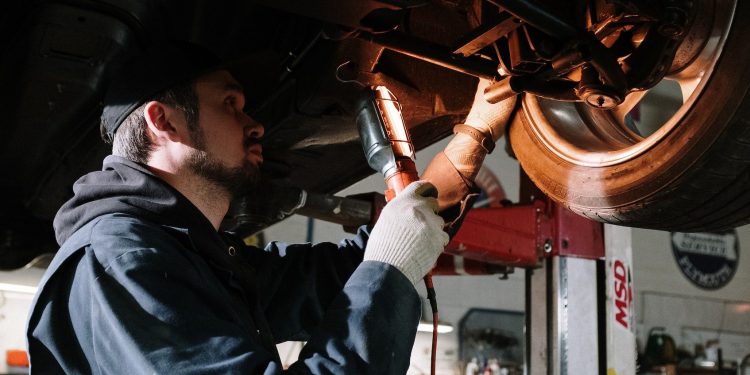 Mechanic inspecting car wheel