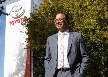 Toyota NZ CEO Neeraj Lala standing next to sign