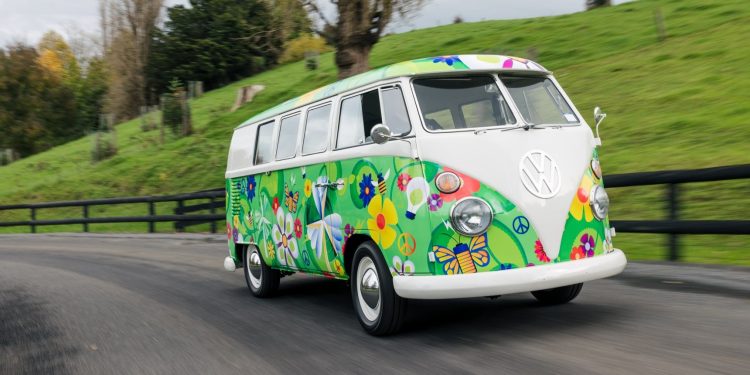 Fully electric Volkswagen Kombi driving past field