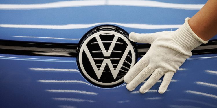 Person putting hand on Volkswagen badge