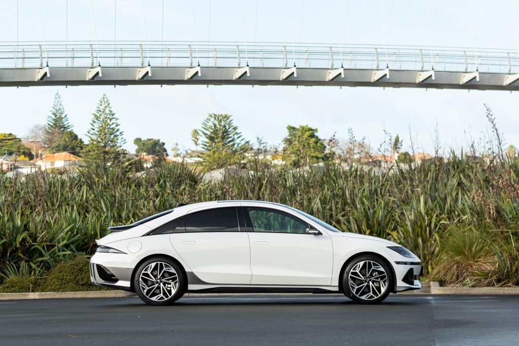 Side profile of the Hyundai Ioniq 6 with a bridge overhead