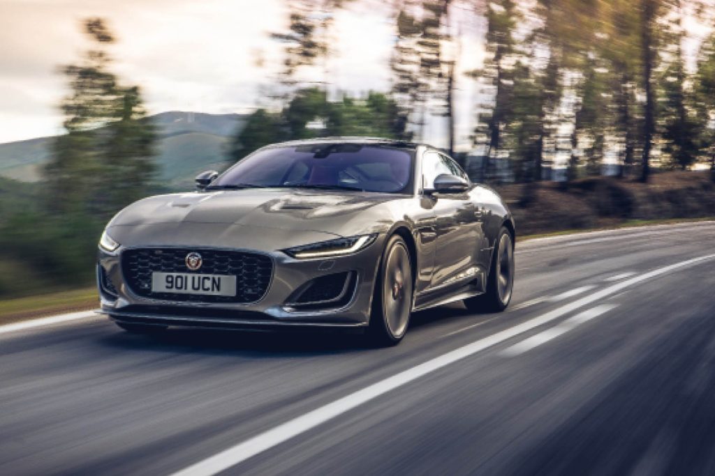 Jaguar F-Type P300 driving on road past trees