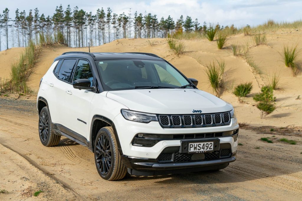 Jeep Compass S 4xe hybrid in white, parked on sand