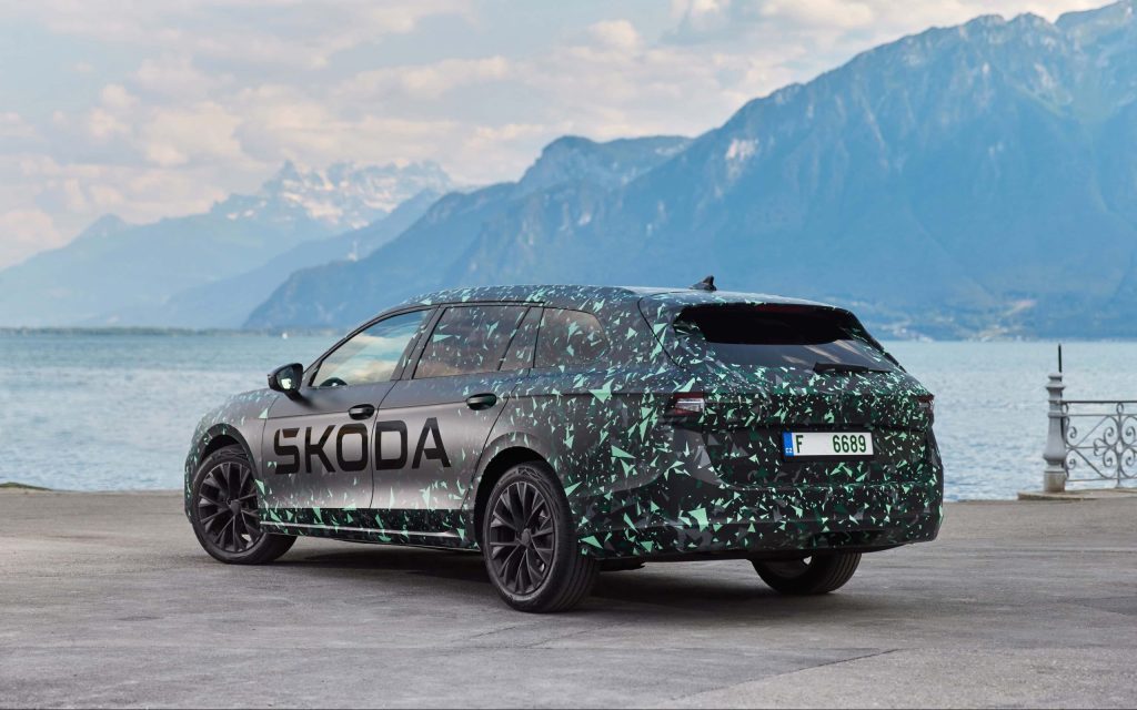 Skoda Superb parked by lake and mountains