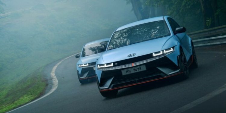 Two Hyundai Ioniq 5 Ns driving on forest road in fog