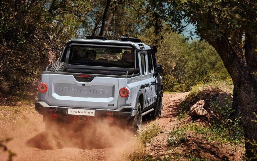 Ineos Grenadier Quartermaster driving up dirt road through trees