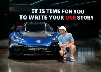 Valtteri Bottas crouching next to his Mercedes-AMG One